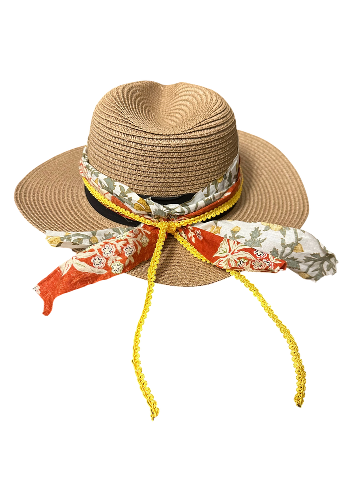 Adams + Hegwood straw fedora hat with a decorative floral fabric band, yellow trim, and dangling ribbon accents.