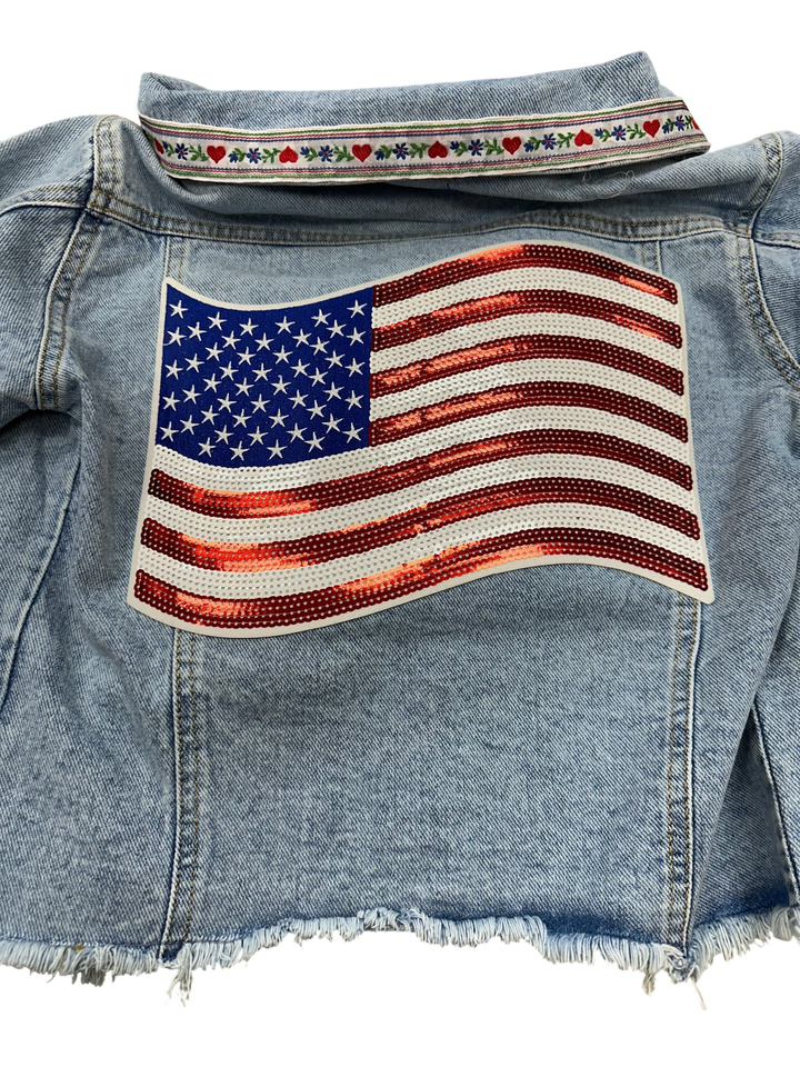 Adams + Hegwood light-wash denim jacket with American flag sequin patch on back and embroidered ribbon collar.