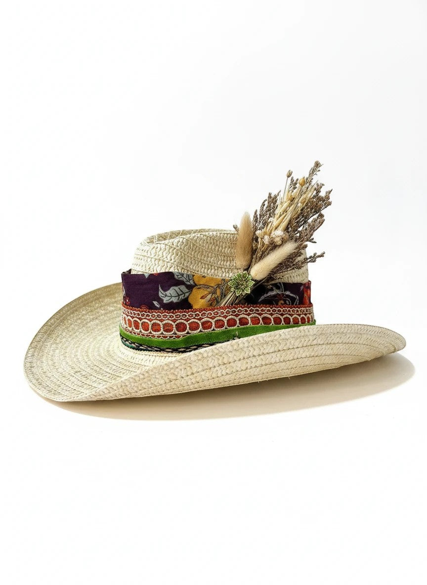 Adams + Hegwood straw cowboy hat with decorative band featuring dried flowers and a floral pattern.