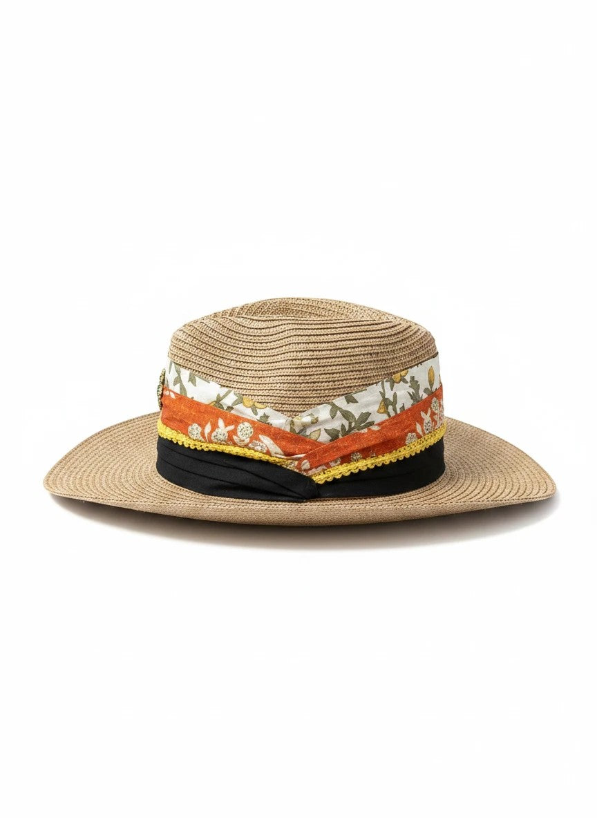 Adams + Hegwood straw fedora hat with a decorative multi-layered fabric band, floral print, and vintage brooch.