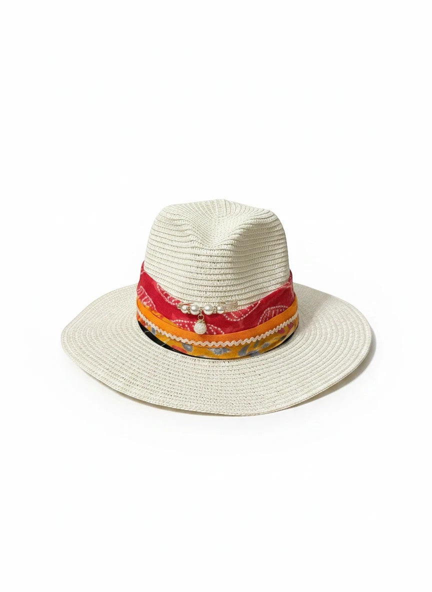Adams + Hegwood cream straw fedora hat with a colorful patterned scarf band, pearl accents, and a charm.