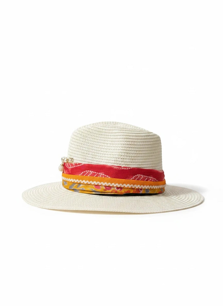 Adams + Hegwood straw fedora hat with a colorful red and orange patterned fabric band and decorative pearl charm.