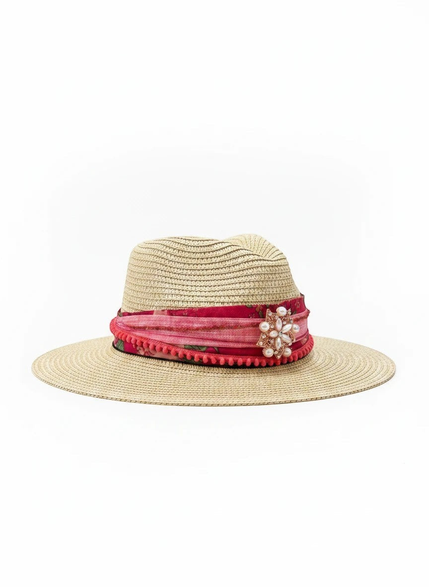 Adams + Hegwood straw fedora hat with pink floral band, pom-pom trim, and pearl brooch.