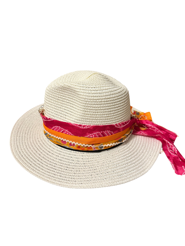 Adams + Hegwood straw fedora hat with a colorful pink and orange patterned scarf band against a black background.