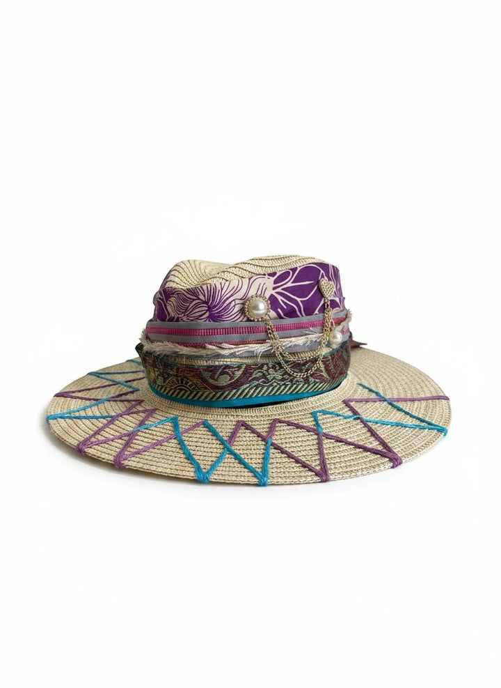 Adams + Hegwood decorative woven straw sun hat with purple floral fabric, pearl charms, and geometric embroidery.