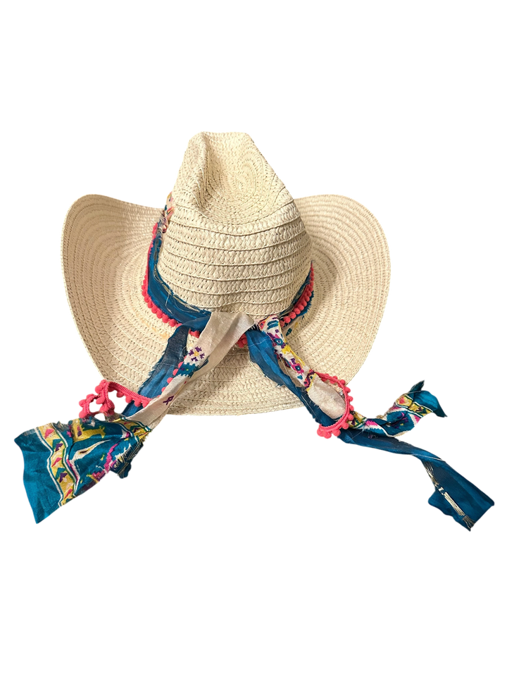 Adams + Hegwood woven straw Western hat with blue patterned fabric band, pink pom-poms, and bohemian style.