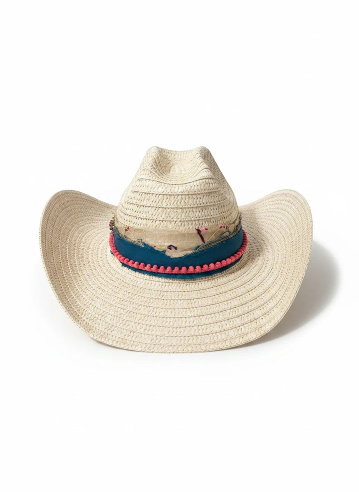 Adams + Hegwood woven straw Western hat with a blue fabric band, pink pom-pom trim, and floral accents.