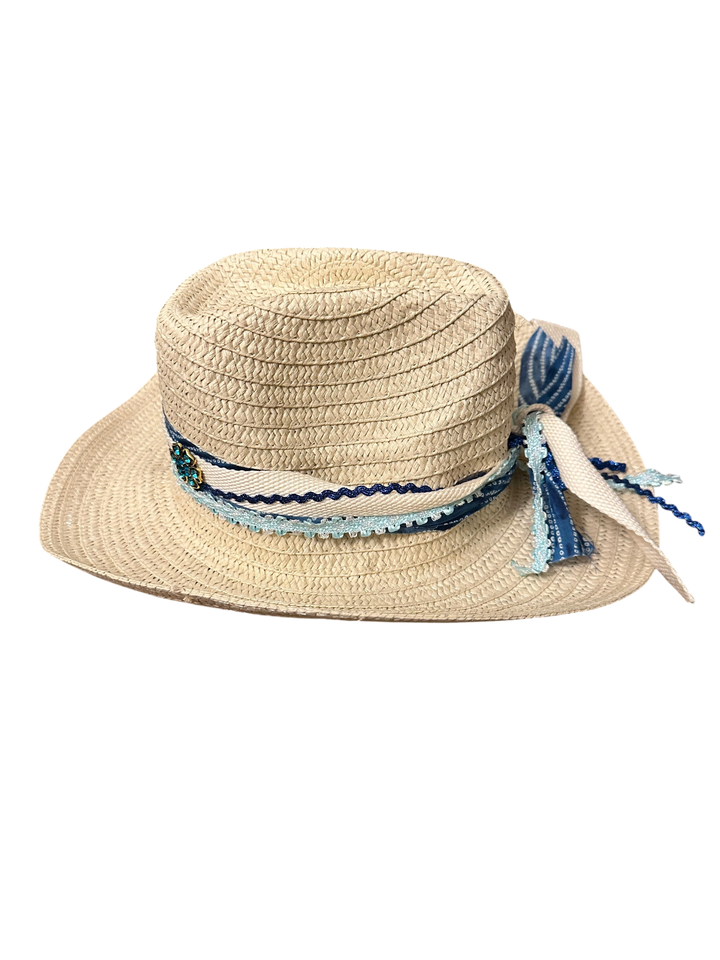 Adams + Hegwood woven straw western sun hat with blue patterned ribbon, crochet trim, and floral accent.