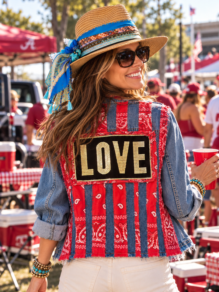 Woman at a tailgate wearing The Denim Muse handmade denim jacket, back view showing red bandana stripes and a gold sequin LOVE patch