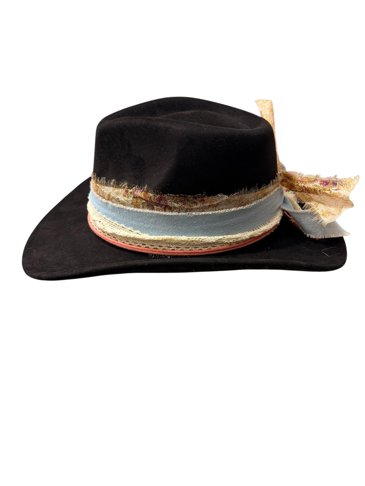Natalie Adams Hegwood Studio black suede hat featuring a decorative frayed ribbon band with floral and blue accents