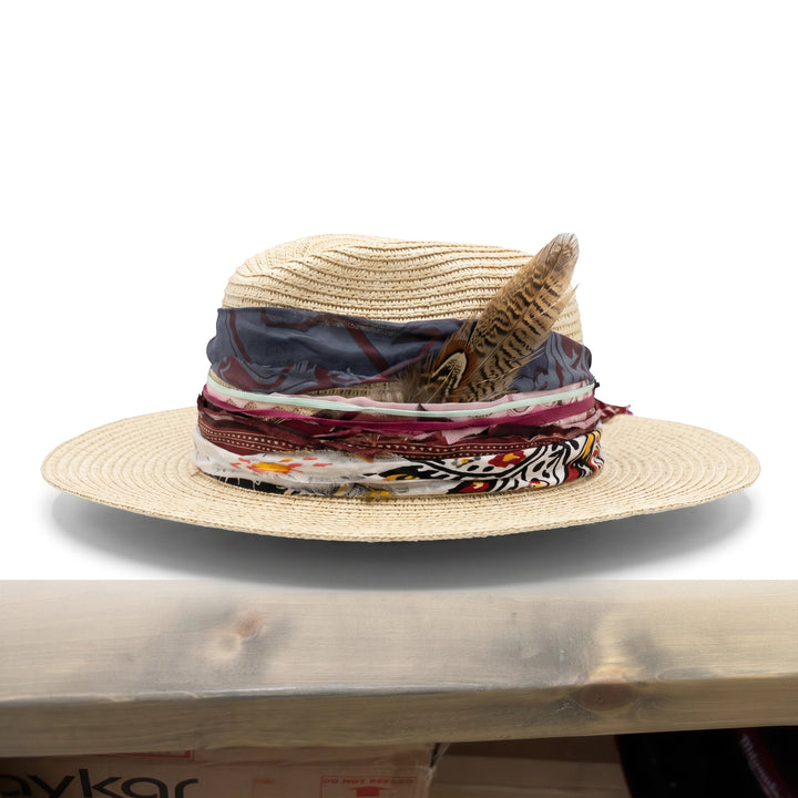 Natalie Adams Hegwood Studio wide brim straw hat with layered fabric ribbons, vintage trims, and a natural feather accent.