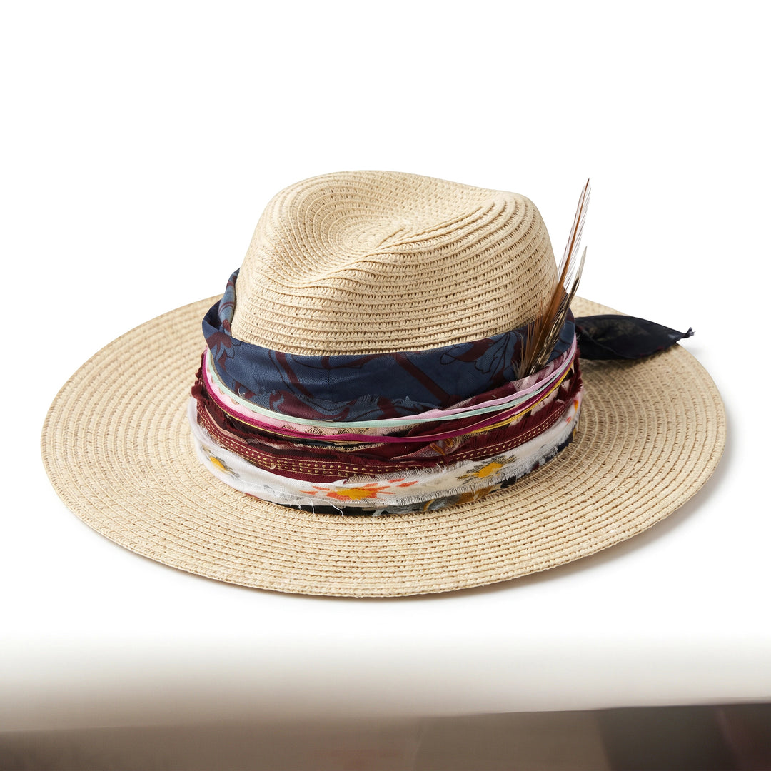 Natalie Adams Hegwood Studio bohemian straw hat with wide brim, layered fabric ribbons, and natural feather accents.