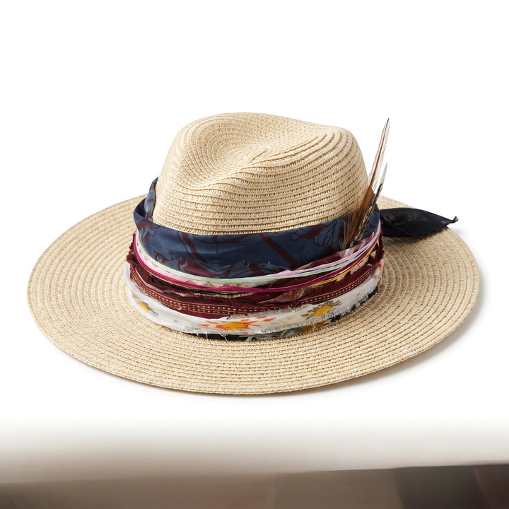 Natalie Adams Hegwood Studio bohemian straw hat with wide brim, layered fabric ribbons, and natural feather accents.