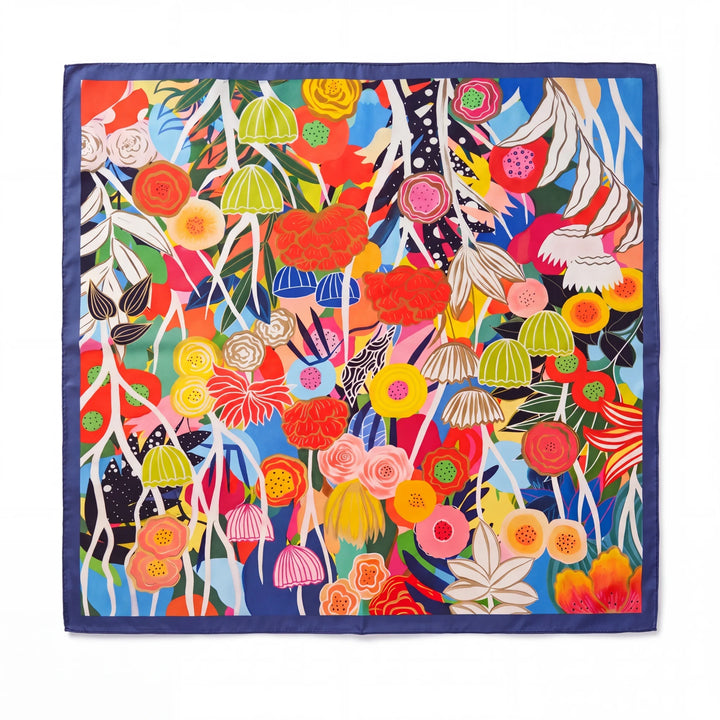 Natalie Adams Hegwood Studio square silk scarf with a vibrant multi-colored botanical floral print and blue border.