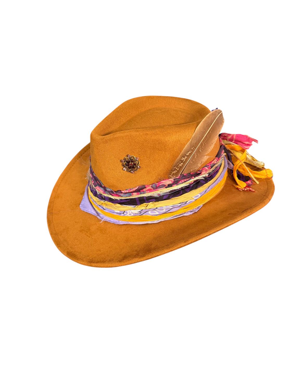 Natalie Adams Hegwood Studio cognac suede western hat with a wide brim, silk band, bronze brooch, and natural feather.