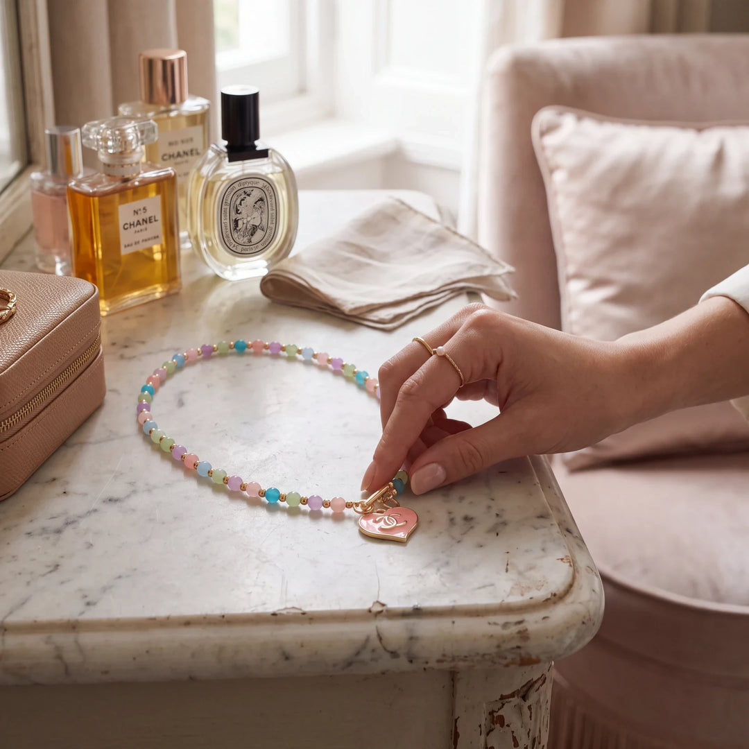 Natalie Adams Hegwood Studio pastel beaded necklace with a pink heart charm on a marble vanity table