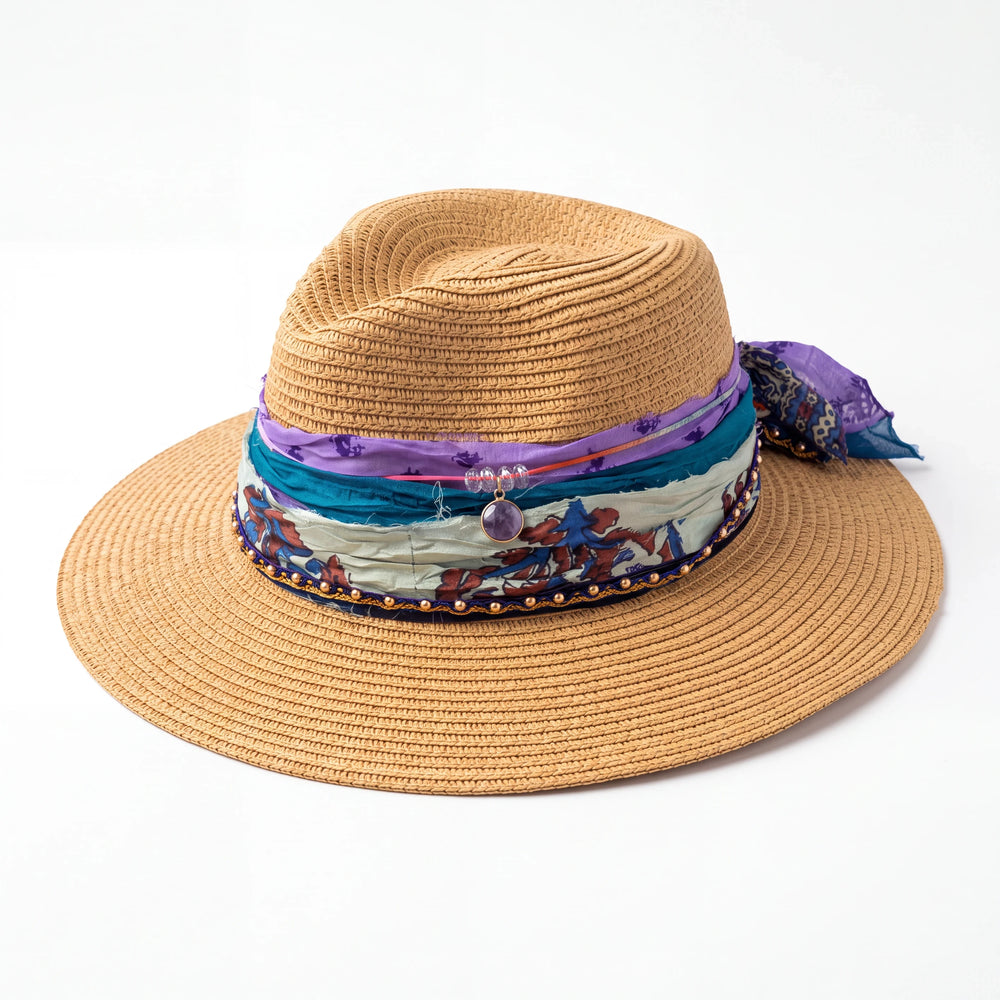 Natalie Adams Hegwood Studio straw fedora with layered purple and teal silk ribbons, gold beads, and a purple stone.