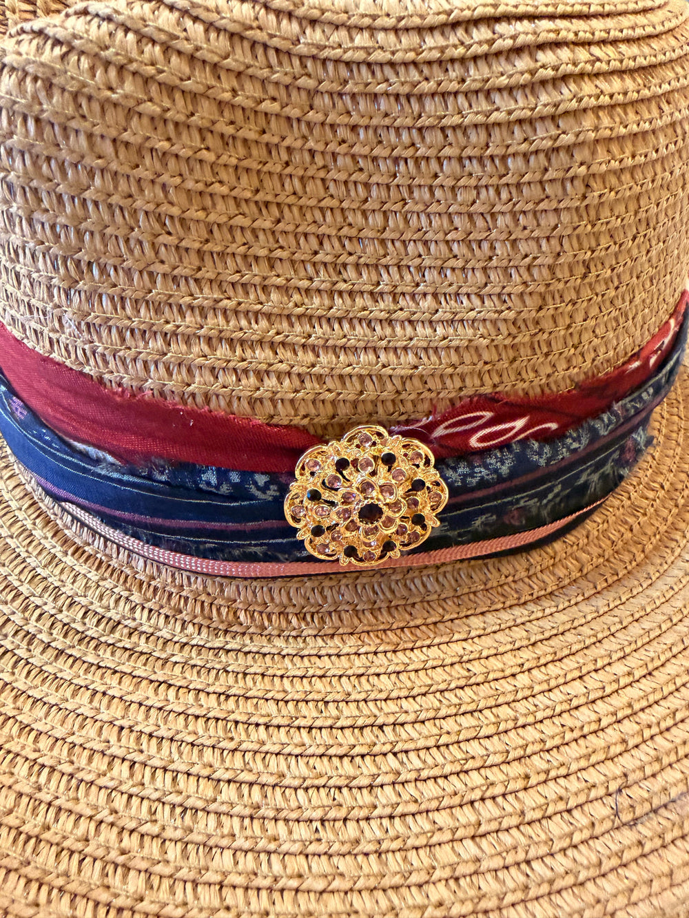 Natalie Adams Hegwood Studio straw fedora with cranberry and navy layered fabric band and gold filigree flower brooch.