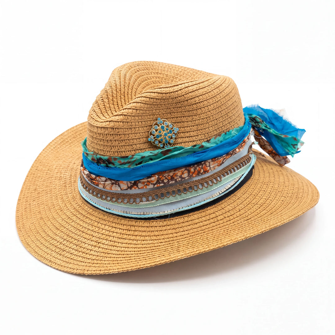 Natalie Adams Hegwood Studio straw fedora with a layered cobalt blue silk, copper print, and jeweled gold brooch band.