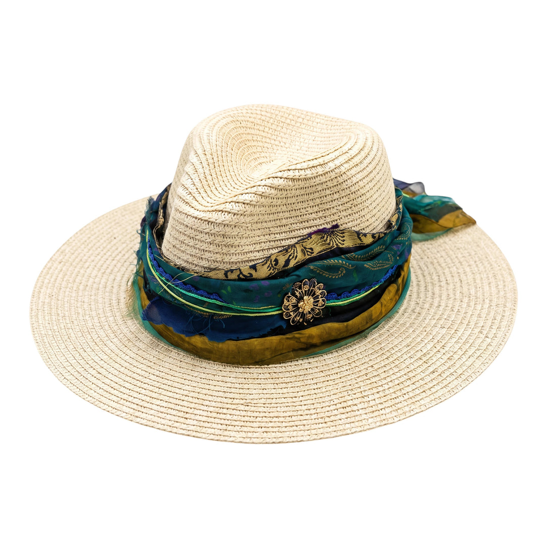 Natalie Adams Hegwood Studio wide brim straw fedora with a layered teal, blue, and green fabric band and floral brooch.