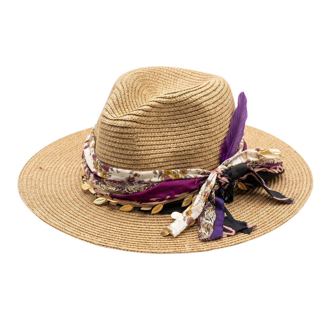 Natalie Adams Hegwood Studio straw fedora with wide brim, floral fabric band, metallic leaf charms, and purple feather.