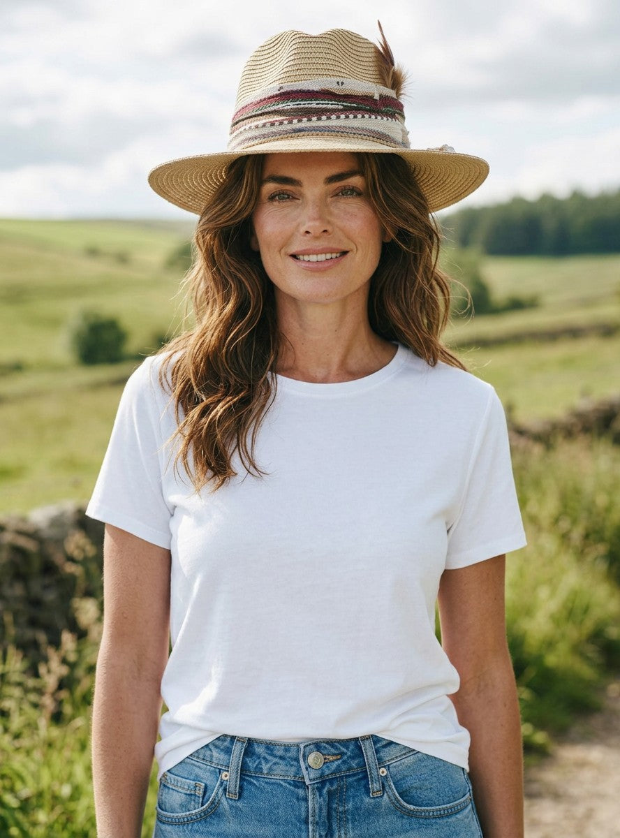 Natalie Adams Hegwood Studio model wearing a straw fedora with a patterned band and a classic white t-shirt outdoors