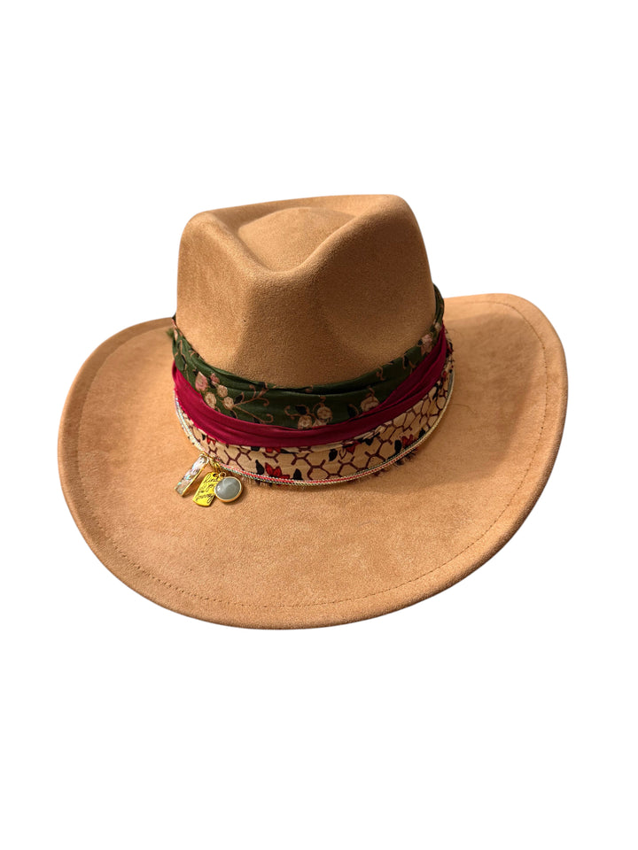 Natalie Adams Hegwood Studio tan suede cowgirl hat with a decorative layered fabric band and gold charm accents.