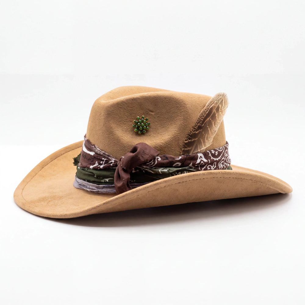 Natalie Adams Hegwood Studio handmade tan suede western hat with a layered bandana band, feather, and green brooch.