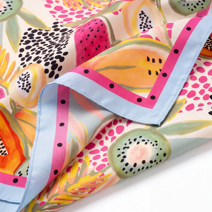 Natalie Adams Hegwood Studio square silk scarf with vibrant tropical fruit print and pastel blue polka-dot border.