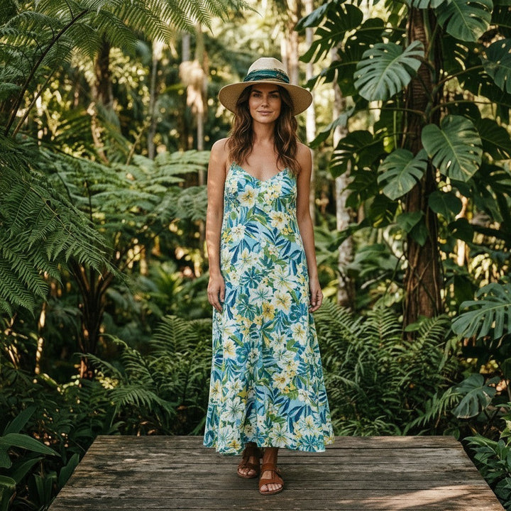 Natalie Adams Hegwood Studio wide brim straw fedora with a colorful fabric band worn by a woman in a tropical garden.